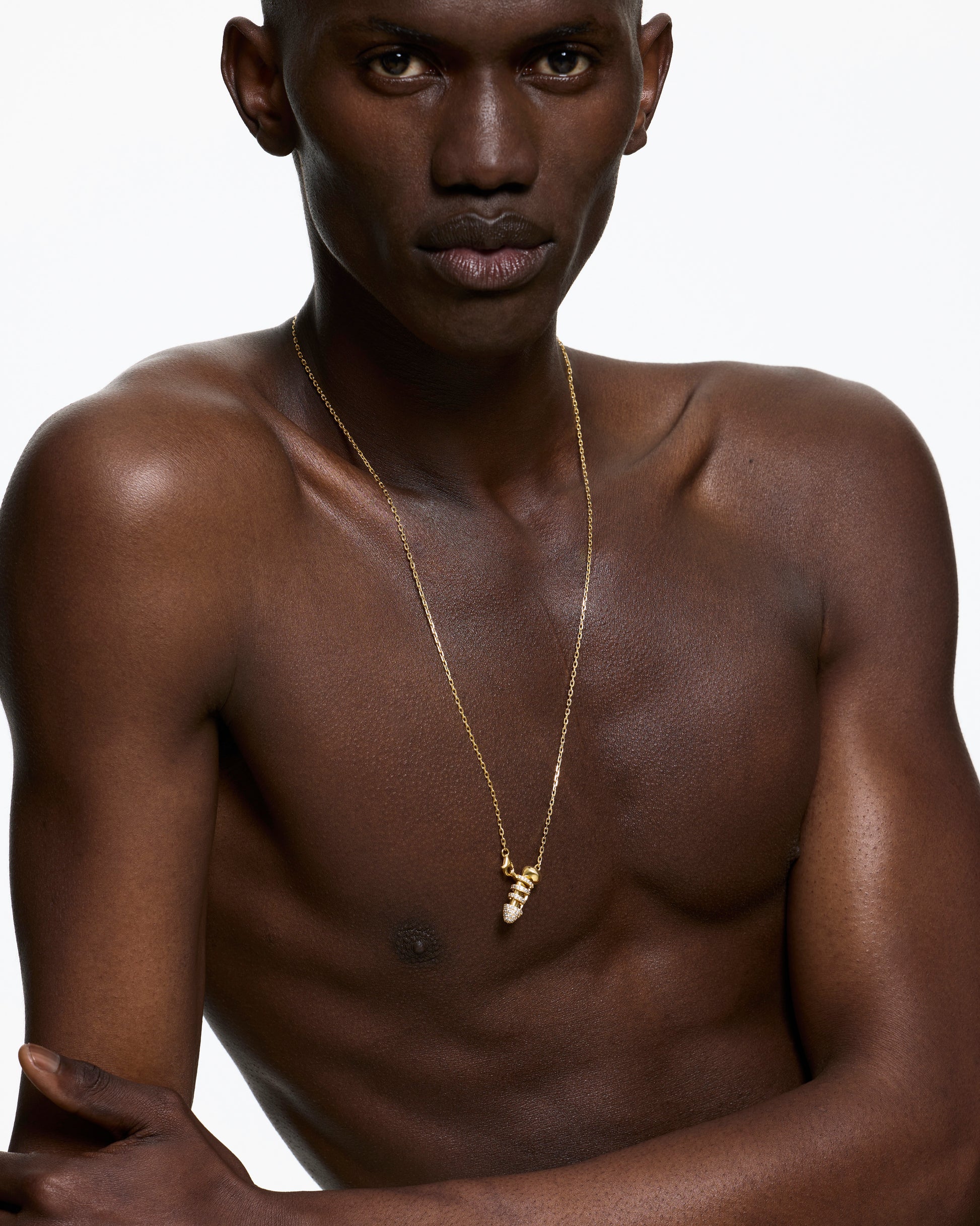 Man wearing a gold chastity necklace on a white background