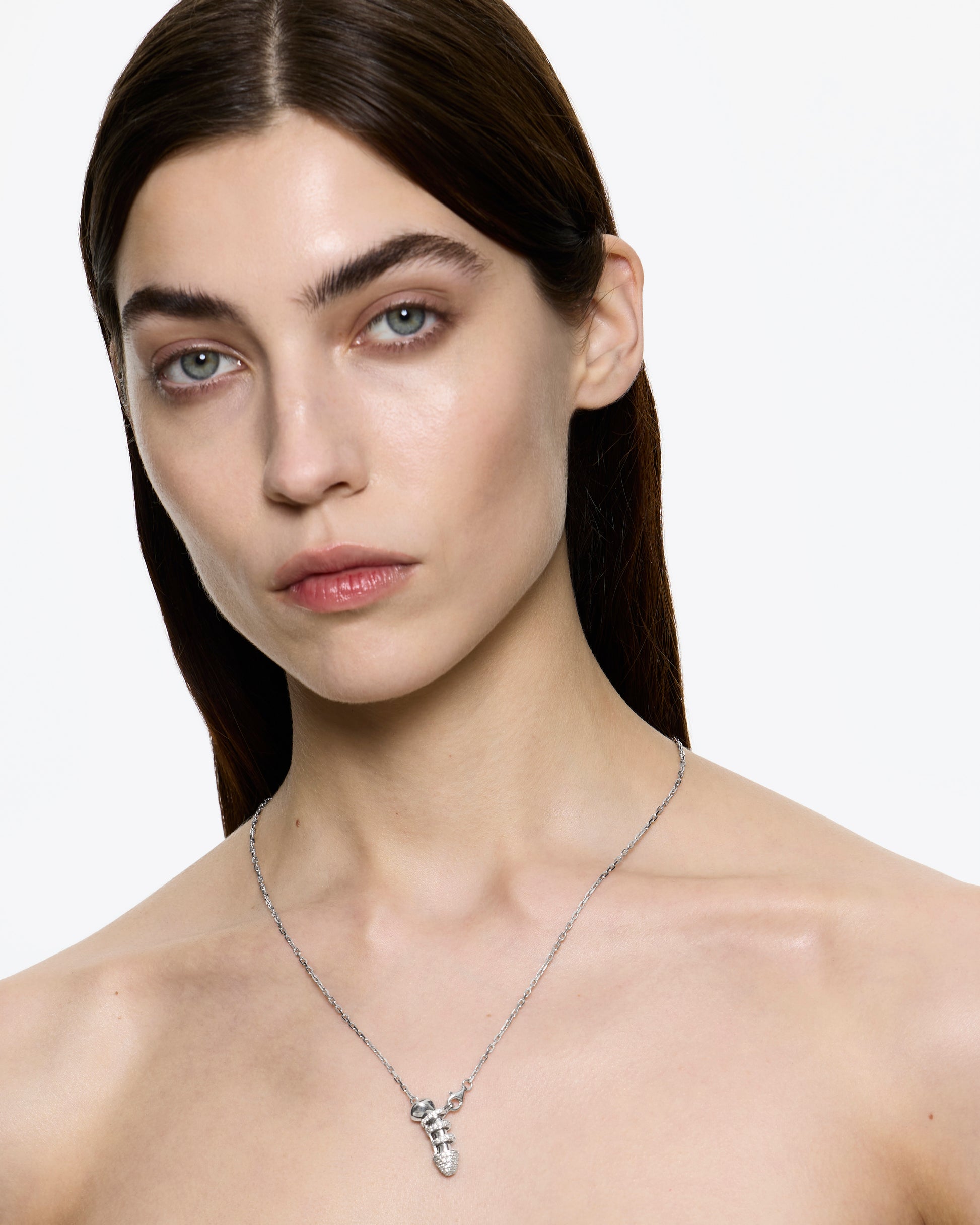 Woman wearing an encrustred chastity necklace in Rhodium on a white background