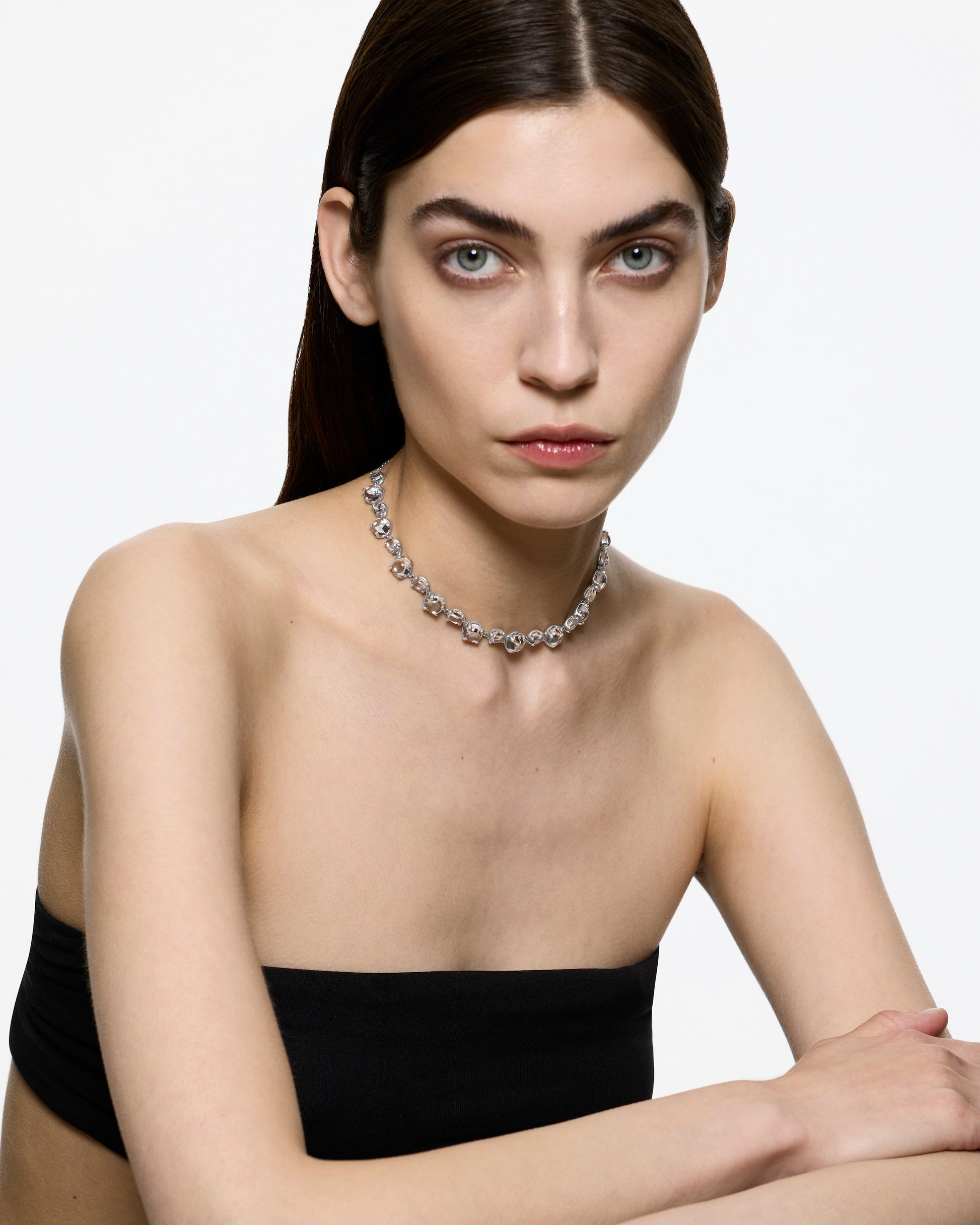 Model wearing the Alan Crocetti Dew Choker, a sculptural silver necklace set with luminous clear cabochon crystals