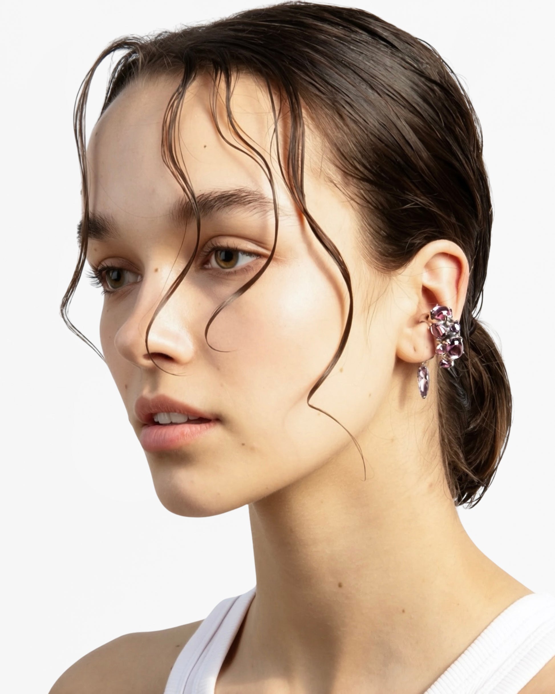 Model wears Alan Crocetti rhodium vermeil ear cuff with purple cabochons and drop charm