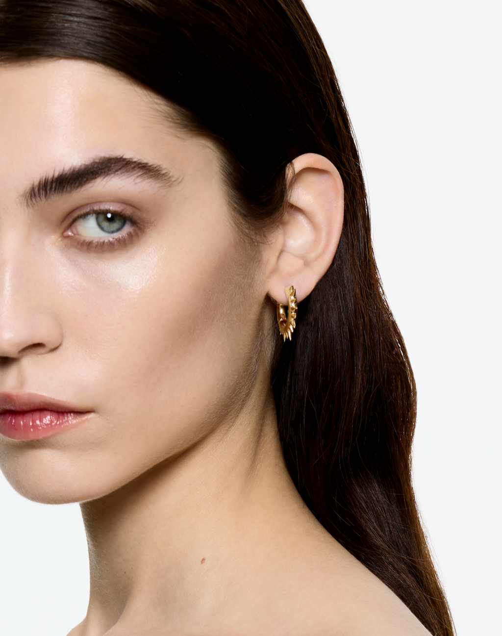 Mini Loophole Spur Earring — sculptural sterling silver spiked earring with gold vermeil finish worn on model up close by Alan Crocetti