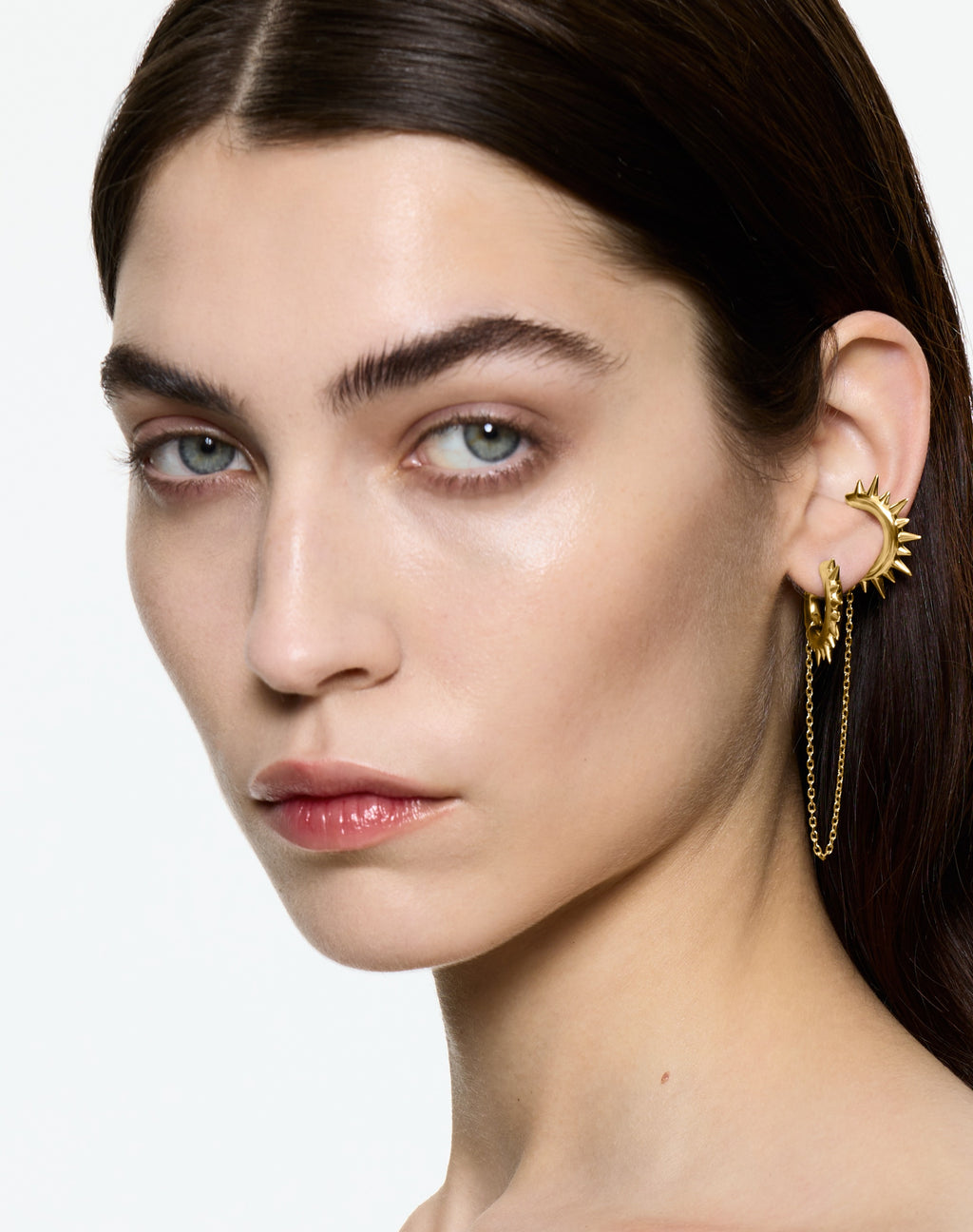 Model wears Mini Loophole Spur Earset — gold vermeil sculptural spur hoop earset with connecting chain by Alan Crocetti